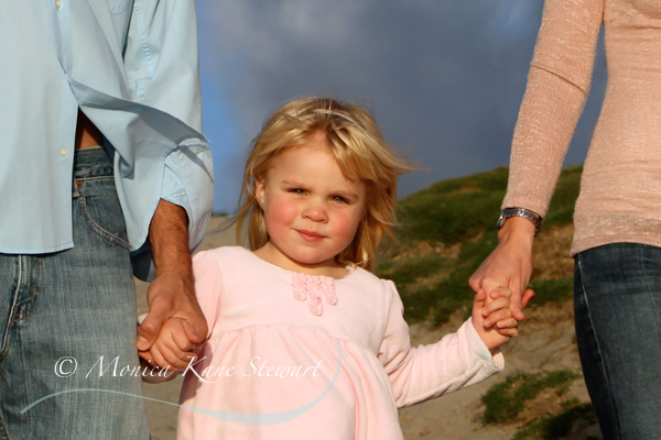 girl holding hands with parents